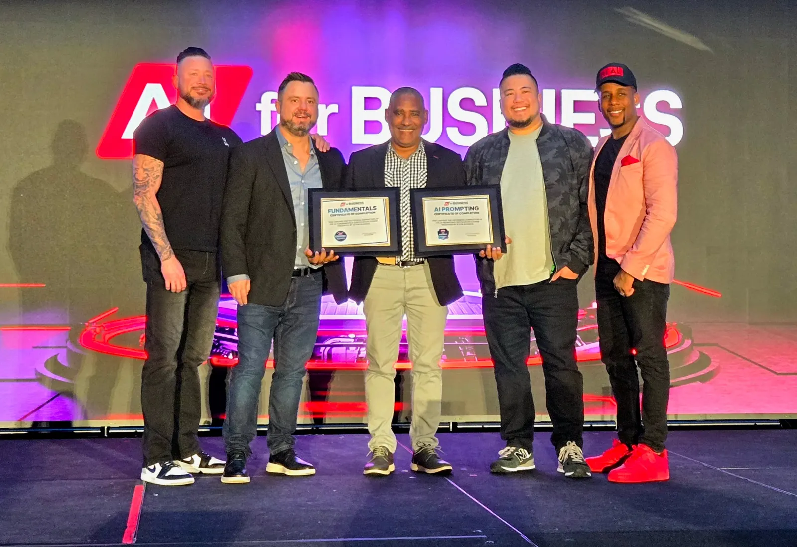 Kurtis Rudd receiving AI for Business certificates on stage