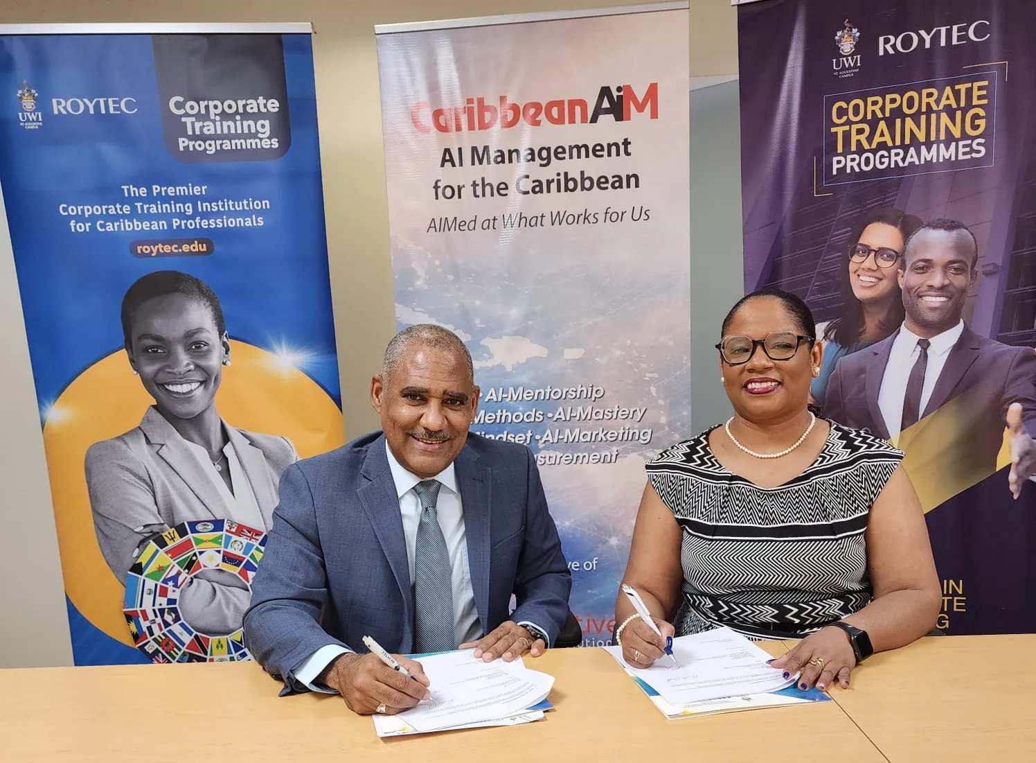 Kurtis Rudd signing a CaribbeanAIM × UWI-ROYTEC Corporate Training partnership MOU